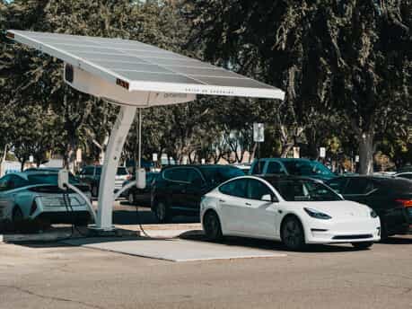 electric cars plugged into a solar powered ev charging station